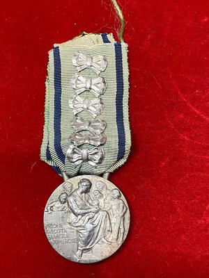 obverse: VENTENNIO FASCISTA. Vittorio Emanuele III (1900-1943). Medaglia d onore per le madri di famiglie numerose, nastrino originale con 6 fiocchi. SPL