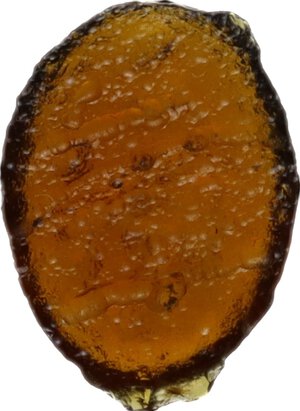 reverse: Orange glass paste decorated with winged Nike.  Roman period, 1st-3rd century AD.  10 mm
