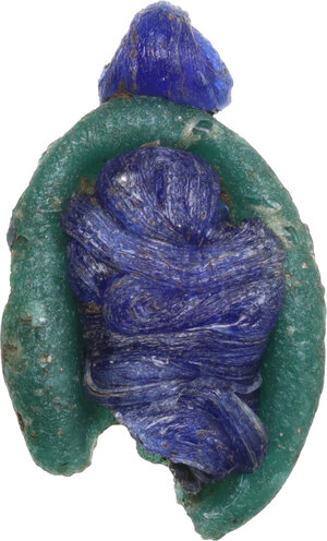 reverse: PHOENICIAN GLASS PASTE HEAD  Punic culture, c. 5th century BC.  Green and blue glass paste pendant, depicting a face with hair gathered in the back.  Dimensions: 21 x 12 mm