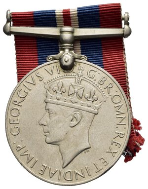 obverse: Medaglie Estere – Regno Unito – Giorgio VI (1936-1952) – WW2 – 1939-45. La medaglia di guerra 1939-1945 è una medaglia di campagna istituita dal Regno Unito il 16 agosto 1945, per l assegnazione ai cittadini del Commonwealth britannico che avevano prestato servizio a tempo pieno nelle forze armate o nella marina mercantile per almeno 28 giorni tra 3 settembre 1939 e 2 settembre 1945. La durata della Seconda guerra mondiale in Europa andò dal 3 settembre 1939 all 8 maggio 1945, mentre nel Pacific Theatre continuò fino al 2 settembre 1945. La War Medal 1939-1945 fu istituita dal Regno Unito il 16 agosto 1945 e fu insignita a tutto il personale a tempo pieno delle forze armate e della marina mercantile per aver prestato servizio per 28 giorni, indipendentemente dal luogo in cui prestava servizio, tra il 3 settembre 1939 e il 2 settembre 1945 compreso, per l intera durata della Seconda guerra mondiale. Nella Marina mercantile, i 28 giorni dovevano essere serviti ovunque in mare. Il requisito di qualificazione per l assegnazione della medaglia di guerra 1939-1945 al personale militare a tempo pieno era di 28 giorni di servizio, ovunque resi. Il servizio di qualificazione nella Marina mercantile era di 28 giorni di servizio ovunque in mare durante il periodo di qualificazione. Anche i cittadini stranieri incaricati o arruolati nelle forze britanniche, che non avevano ricevuto un premio simile alla medaglia di guerra 1939-1945 dai propri governi, potevano qualificarsi per l assegnazione di questa medaglia. I membri retribuiti a tempo pieno delle forze coloniali e di altre forze militari appositamente approvate, della polizia militarizzata o degli organismi civili militarizzati che erano idonei a qualificarsi per le stelle della campagna, potevano anche qualificarsi entro 28 giorni di servizio durante il periodo di qualificazione previsto per la forza interessati, come segue: Polizia armata di Aden dal 3 febbraio 1939 al 2 settembre 1945. British Honduras Defence Force dal 3 settembre 1939 al 3 dicembre 1939. Polizia della Guyana britannica, esclusi coloro che hanno cessato di appartenere alla Forza per motivi diversi da morte, cattiva salute o età, dal 3 settembre 1939 al 14 luglio 1945. Banda militare della Guyana britannica dal 29 aprile 1942 all 8 maggio 1945. Forza di polizia di Cipro impiegata in servizio militare a tempo pieno dal 10 giugno 1940 al 12 giugno 1941. Forza volontaria di Cipro dal 2 giugno 1941 al 2 settembre 1945. Gambia Police Force dal 5 luglio 1940 al 17 agosto 1940. Trasporto per acque interne dell esercito gambiano sulla SS Munshi dal 21 luglio 1942 al 31 maggio 1944. Gibraltar Defence Force dal 3 settembre 1939 al 2 settembre 1945. Polizia di sicurezza di Gibilterra dal 3 settembre 1939 al 2 settembre 1945. Forza di polizia della Nigeria dal 23 luglio 1940 all 8 maggio 1945. Forza di polizia palestinese dal 27 maggio 1942 all 8 maggio 1945. Sudan Defence Force per il servizio permanente a tempo pieno ovunque nel Sudan dal 3 settembre 1939 all 8 maggio 1945. Trinidad Police Force dal 3 settembre 1939 al 2 settembre 1945. Zanzibar Police Force dal 3 settembre 1939 al 2 settembre 1945. La qualifica per le categorie appositamente approvate di civili in uniforme che potevano qualificarsi per le stelle della campagna era di 28 giorni di servizio nell area di un comando operativo dell esercito all estero, o all estero da o fuori dal paese di residenza in aree non operative soggette a nemico attacco aereo o minacciato da vicino. Il servizio nel Regno Unito o nel territorio di residenza, diverso da un area operativa dell esercito, non era una qualifica per queste categorie. La medaglia è stata assegnata al personale il cui periodo di servizio richiesto è stato interrotto prematuramente per morte, disabilità dovuta al servizio o alla cattura come prigioniero di guerra e il cui servizio li ha qualificati per una delle stelle della campagna della Seconda guerra mondiale. Anche il personale che aveva ricevuto una delle stelle per un servizio inferiore a 28 giorni ricevette la medaglia di guerra 1939-1945. La medaglia di guerra 1939-1945 è un disco di 36 millimetri di diametro. La bretella a barra dritta non girevole è attaccata alla medaglia con un attacco ad artiglio a punta singola e un perno attraverso il bordo superiore della medaglia. Le medaglie di emissione britannica erano coniate in cupronichel, mentre quelle assegnate in Canada (circa 700.000) erano coniate in argento. La medaglia viene talvolta erroneamente chiamata 