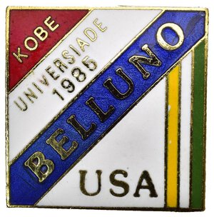 obverse: Medaglie Estere – Stati Uniti d’America (USA) – Universiade 1985 - Belluno. Spilla emessa a ricordo dell’Universiade del 1985 svoltasi a Belluno in Italia dal 16 al 24 febbraio 1985 ed indossata dagli atleti degli Stati Uniti. Al dritto su vari campi colorati la scritta BELLUNO, KOBE (successiva Universiade), UNIVERSIADE 1985 e USA.  Al rovescio spilla portativa. Realizzata in bronzo dorato (AE) e smalti policromi (25x25mm, 7.2gr). Conservazione FDC