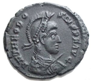 obverse: Teodosio I (379-395 d.C.) AE 2 (5,36 g. 24,45 mm) Thessalonica (Salonicco) 2°officina 383-388 d.C. d/ Busto a ds con elmo, diadema di perle, panneggio, corazza, lancia e scudo r/ Imperatore insieme a Vittoria su galea, nel campo a sn ghirlanda In ex • TES B. RIC IX 44b (sig 2). Debolezza di conio al rv. Spl/BB. Patina verde nera