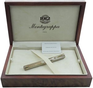 obverse: MONTEGRAPPA Lancaster -Penna Stilografica-. Corpo e cappuccio in argento massiccio 925 a ricami floreali. Ricarica a cartuccia/converter. Pennino EF in oro bianco 18kt. Penna nuova, mai inchiostrata né provata, venduta con tutto il suo corredo completo (da notare la bellissima scatola in legno).. n.d.