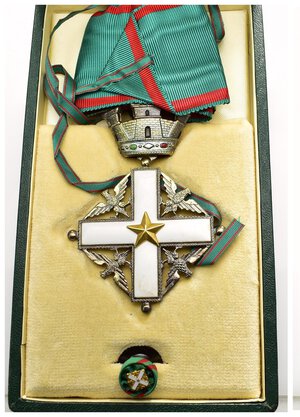 obverse: Medaglie Italiane – Croce Da Commendatore Ordine Merito (III classe) – Repubblica Italiana (Dal 1946) – Tipologia 1951/2001. Croce da Commendatore dell’Ordine al Merito della Repubblica Italiana, nella versione assegnata nel periodo 1951-2001, comprensiva della rosetta per abiti civili. L Ordine al merito della Repubblica italiana (spesso abbreviato OMRI) è il più alto degli ordini della Repubblica italiana. I colori dell ordine sono il verde e il rosso. Il presidente della Repubblica italiana è il capo dell ordine, retto da un consiglio composto di un cancelliere e sedici membri. La cancelleria dell ordine ha sede a Roma. Il cancelliere attuale è il generale di Squadra Aerea Roberto Corsini. Istituito con la legge 3 marzo 1951, n. 178 e reso operativo nel 1952, l Ordine al merito della Repubblica nacque con lo scopo di «ricompensare benemerenze acquisite verso la Nazione nel campo delle lettere, delle arti, dell economia e nell impegno di pubbliche cariche e di attività svolte a fini sociali, filantropici e umanitari, nonché per lunghi e segnalati servizi nelle carriere civili e militari». Il Presidente della Repubblica può conferire l onorificenza, di propria iniziativa, per «benemerenze di segnalato rilievo nel campo delle attività sopra indicate e per ragioni di cortesia internazionale». Dal 30 marzo 2001 sono in vigore le nuove decorazioni per le varie classi di onorificenze. L ordine è suddiviso nei seguenti gradi onorifici: cavaliere di gran croce decorato di gran cordone; cavaliere di gran croce; grande ufficiale; commendatore; ufficiale; cavaliere, detto anche cavaliere della Repubblica (come in questo caso). Al dritto e al rovescio croce latina con smalti bianchi, con stella bronzea a cinque punte al centro, nei quattro angoli quattro aquile ad ali aperte, sopra una corona turrita con smalti bianchi, rossi e versi, nastro verde con filetti rossi ai lati. Realizzata in bronzo dorato (AE) e smalti policromi (74x56mm ca., 45.4g.). Conservazione SPL/FDC. In astuccio d’epoca con distintivo repubblicano in metallo dorato sul piatto anteriore, prodotto dalla ditta Stefano Johnson di Milano - Roma.   