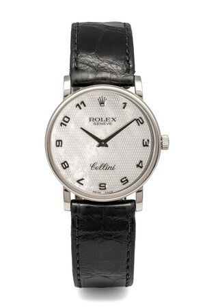 obverse: # ROLEX Cellini. Movimento con calibro 1602 a carica manuale. Referenza 5115/9. Seriale A9XXX. Cassa in oro bianco con diametro da 32mm. Dial bianco madreperla a numeri arabi. Bracciale in pelle con fibbia in oro bianco 18kt, entrambi originali. Vetro zaffiro. Venduto nel 2004. Orologio usato, in eccellente stato conservativo.  Venduto con corredo completo composto da scatola, controscatola, garanzia e libretto d’istruzioni. Perfettamente funzionante. 