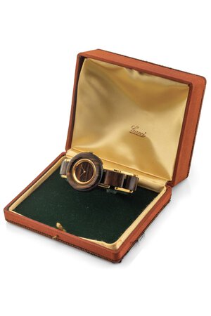 reverse: Gucci Wood, anni 70 Cassa rotonda in legno e oro 18k. Quadrante in legno. Movimento a carica manuale. Bracciale in legno e oro 18k. Dimensioni: 33 mm. Accompagnato da scatola d epoca Gucci.